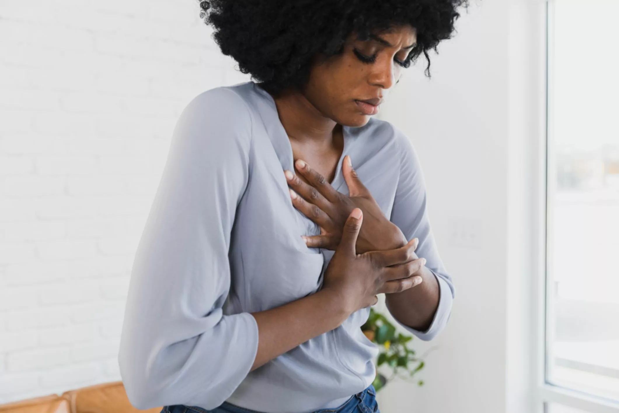 Midden volwassen vrouw houdt borst vast