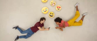 pasangan bahagia berkirim pesan di ponsel pintar mereka, mengirim emoji