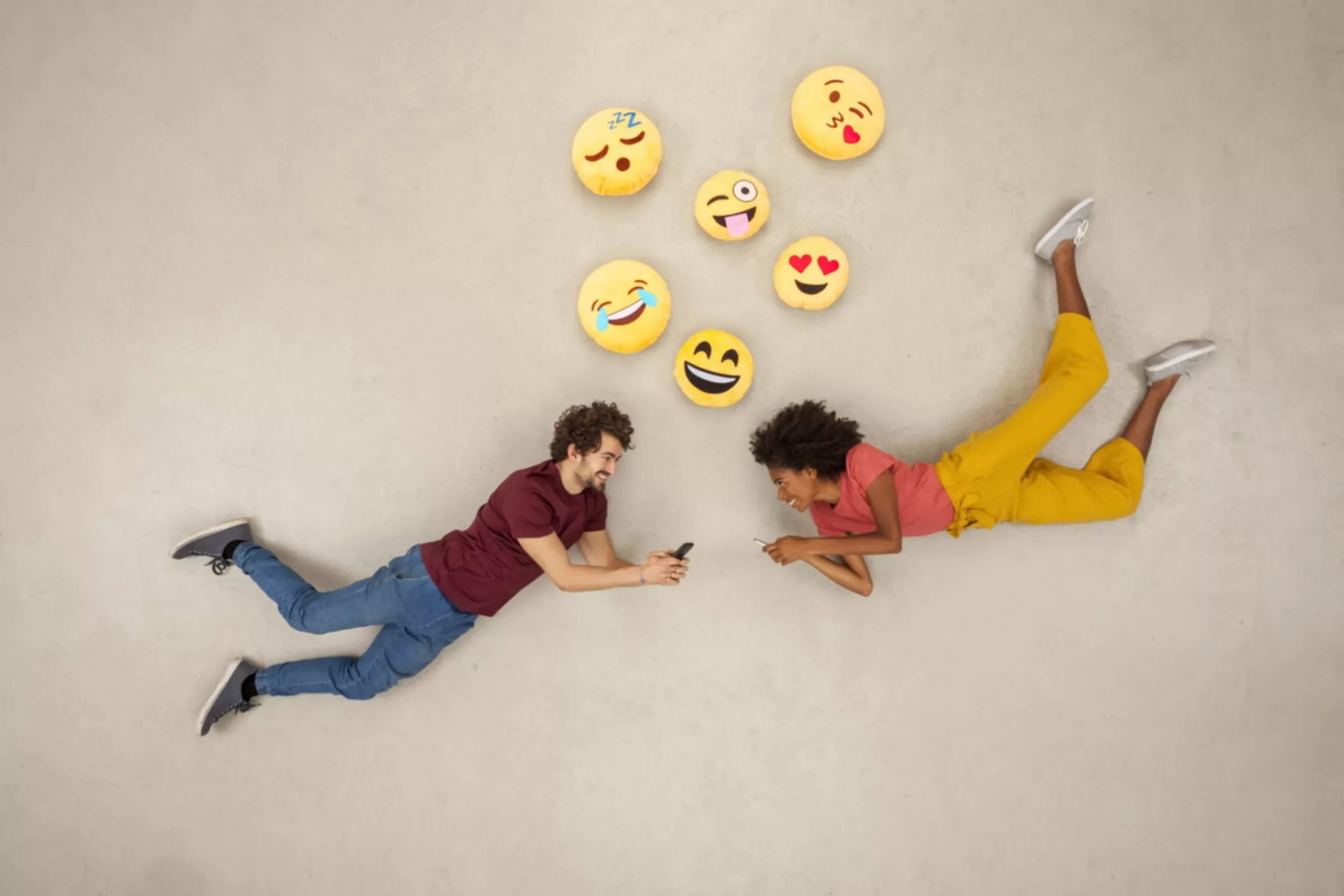 un couple heureux envoyant des textos sur leurs téléphones intelligents, en envoyant des émojies.